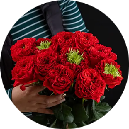 Una trabajadora sostiene un ramo de rosas rojas